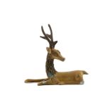 A Chinese copper alloy model of a stag, 19th Century, resting with head turned towards its tail, one