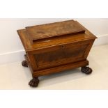 An English mahogany sarcophagus wine cooler, circa 1820, of panelled rectangular form on carved