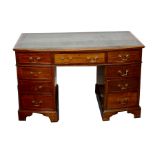 An mahogany double pedestal desk in Georgian style, early 20th Century, with bow front and green