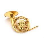 A novelty gold brooch, realistically modelled as a 9 carat gold French horn, maker's mark JC, London