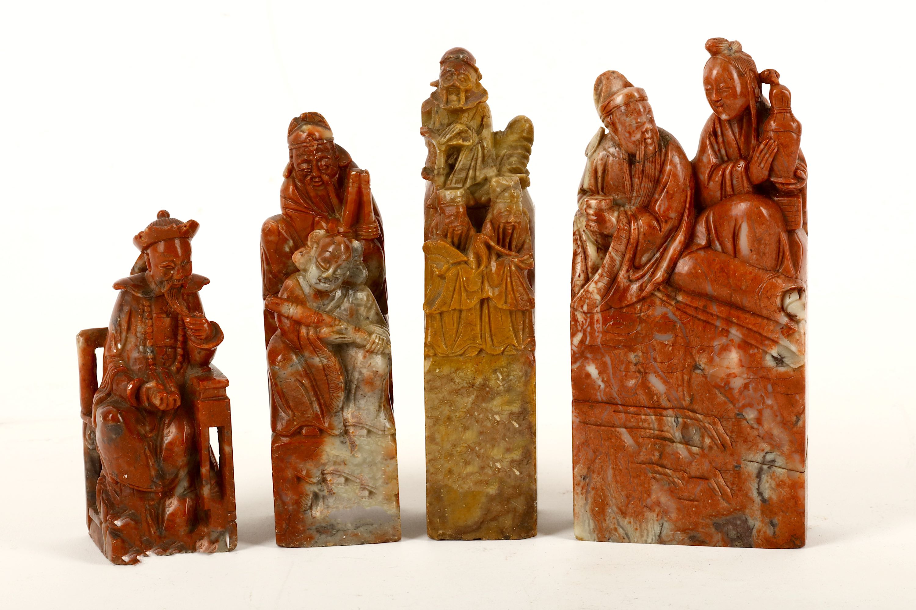Four Chinese carved soapstone figurative seals, 20th Century, depicting a scholar holding a cup