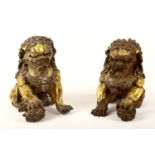 A pair of Chinese gilded metal and bronzed models of recumbent temple lion dogs, 20th Century,