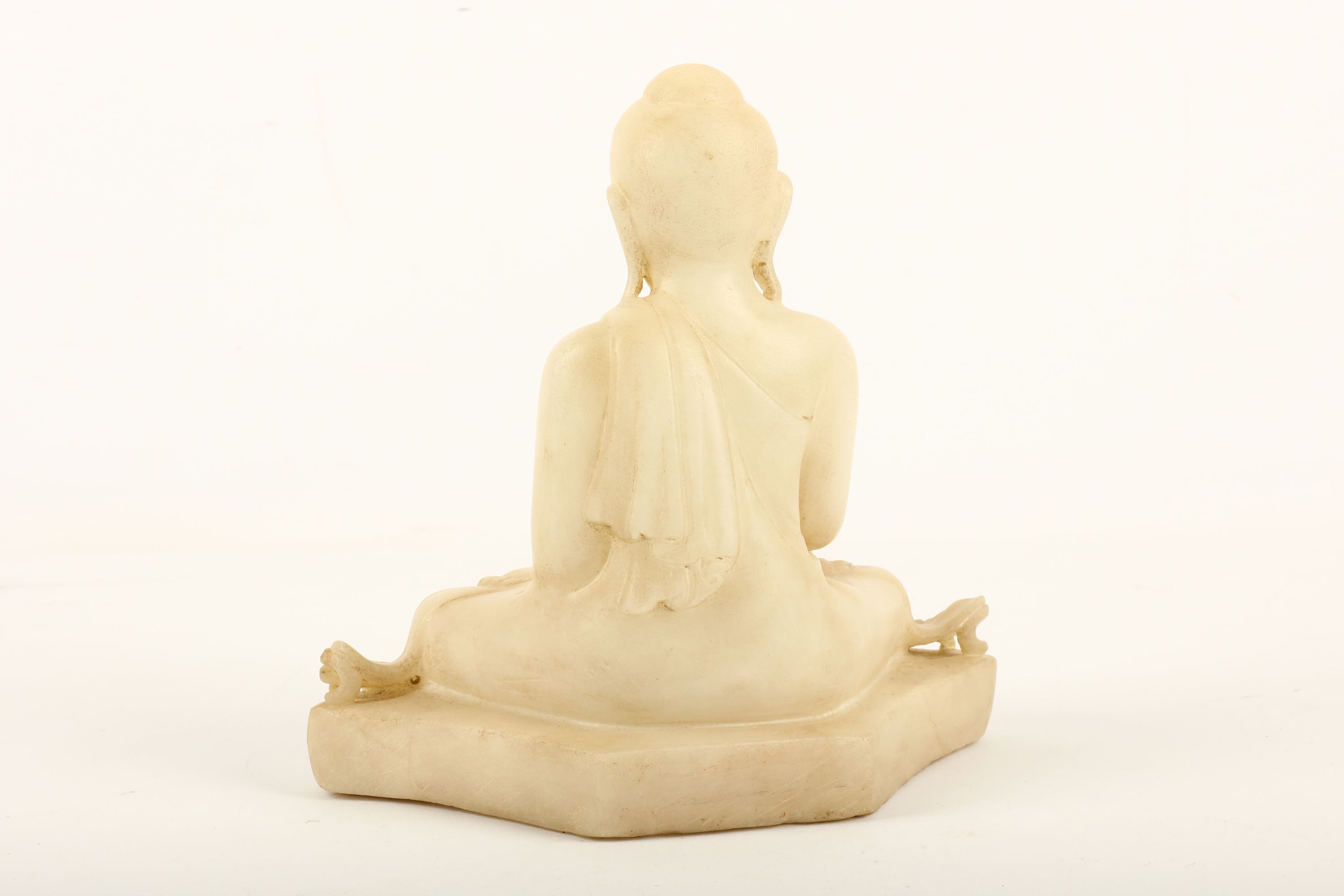 A carved Burmese white marble Buddha, sitting on a base in Bhumisparsha mudra wearing flowing robes, - Image 2 of 2
