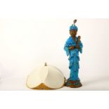 A tall Chinese terracotta and turquoise glazed figure of a sage, supported on a pierced circular
