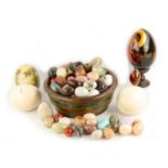 A large collection of glass and hardstone eggs, together with three ostrich eggs, one painted with