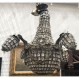 A cast metal and glass chandelier, 20th Century, of basket form, with four scrolling lights, hung