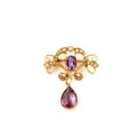 A gold, amethyst and seed pearl brooch, 1909-10, of scrolling form, set with half seed pearls and an