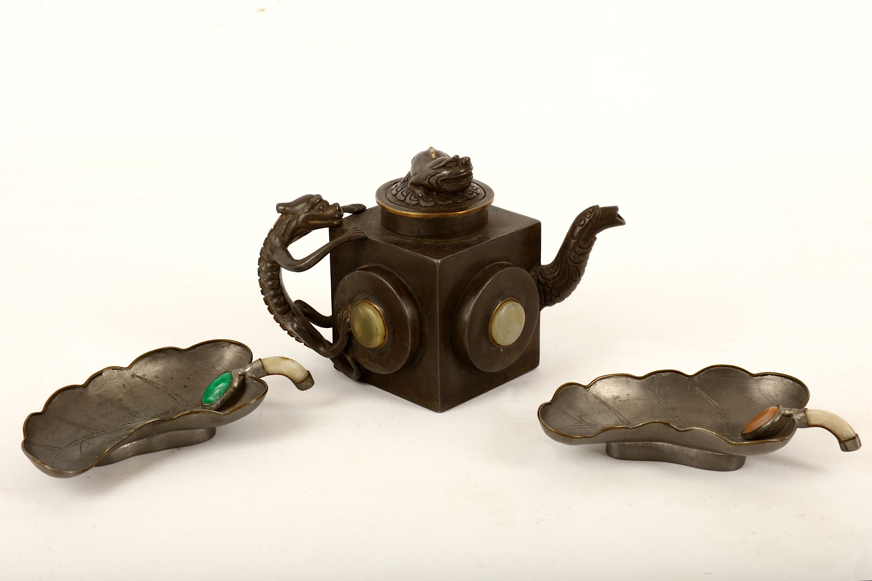 A Chinese pewter teapot and cover together with two cups, the teapot of square shape with hard