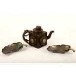 A Chinese pewter teapot and cover together with two cups, the teapot of square shape with hard
