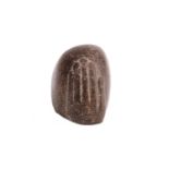 AN EGYPTIAN HAND FRAGMENT In dark stone, the fragment survives with a carved hand, possibly