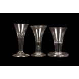 TWO PLAIN-STEMMED CORDIAL OR WINE GLASSES AND A FIRING GLASS