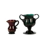 AN UNUSUAL EMERALD-GREEN MOULDED GLASS LOVING CUP AND AN AMETHYST GLASS CREAM JUG
