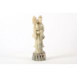 A Chinese carved soapstone figure of a lady, 19th Century, standing on a rocky base wearing