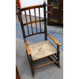 An elm stick-back children's rocking chair, 19th Century, with a twist back and columns, and rush