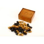A late Victorian or early Edwardian boxwood and stained ebony chess set, of tapering form,