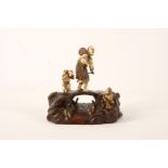 A carved Japanese ivory and wood okimono group, Meiji period, depicting fisherman walking on a