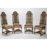 A set of four walnut dining chairs in the style of Daniel Marot, with carved backs and stuff over