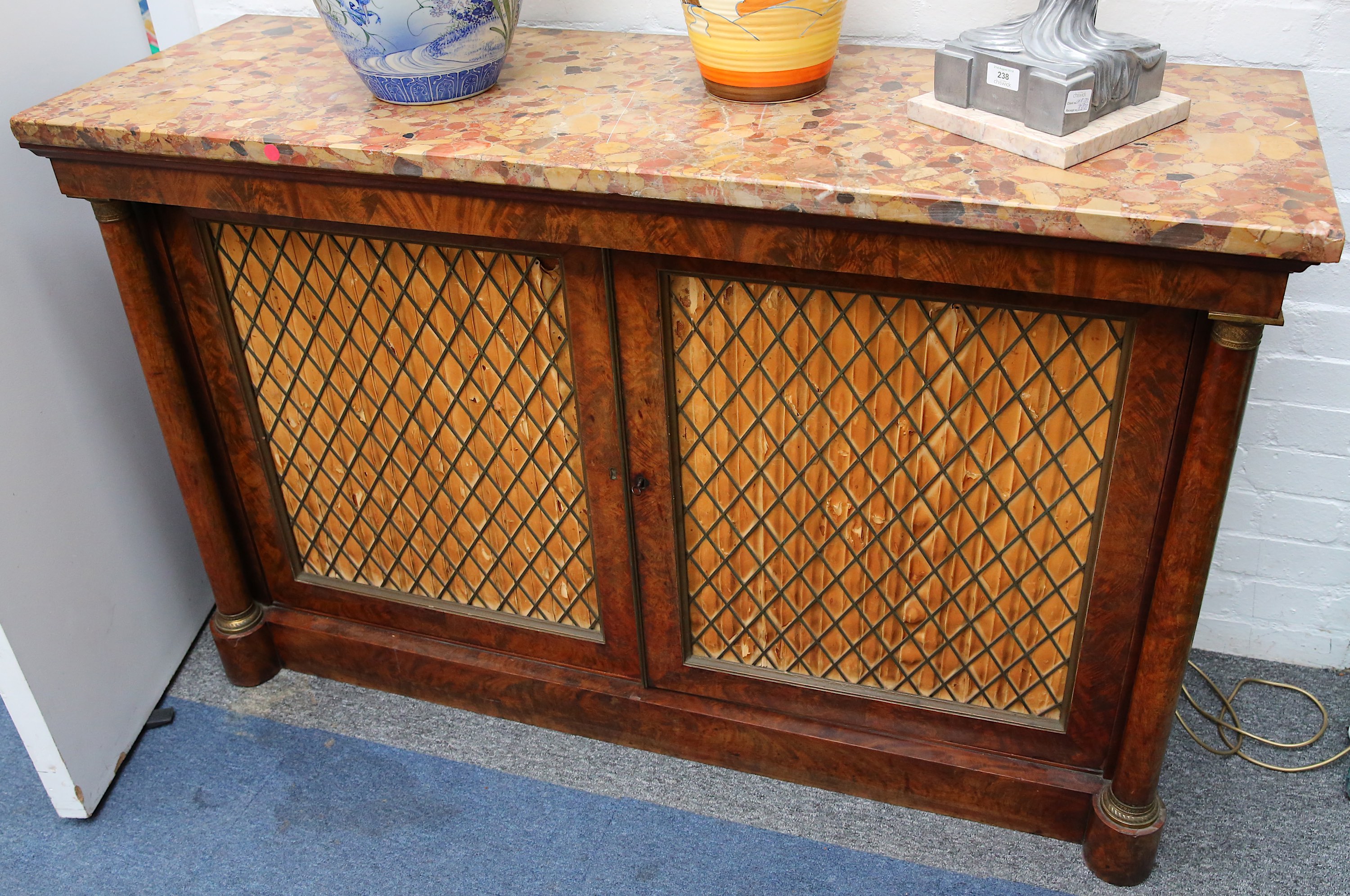 A George IV burr wood side cabinet, the variegated marble top over two brass grill doors flanked