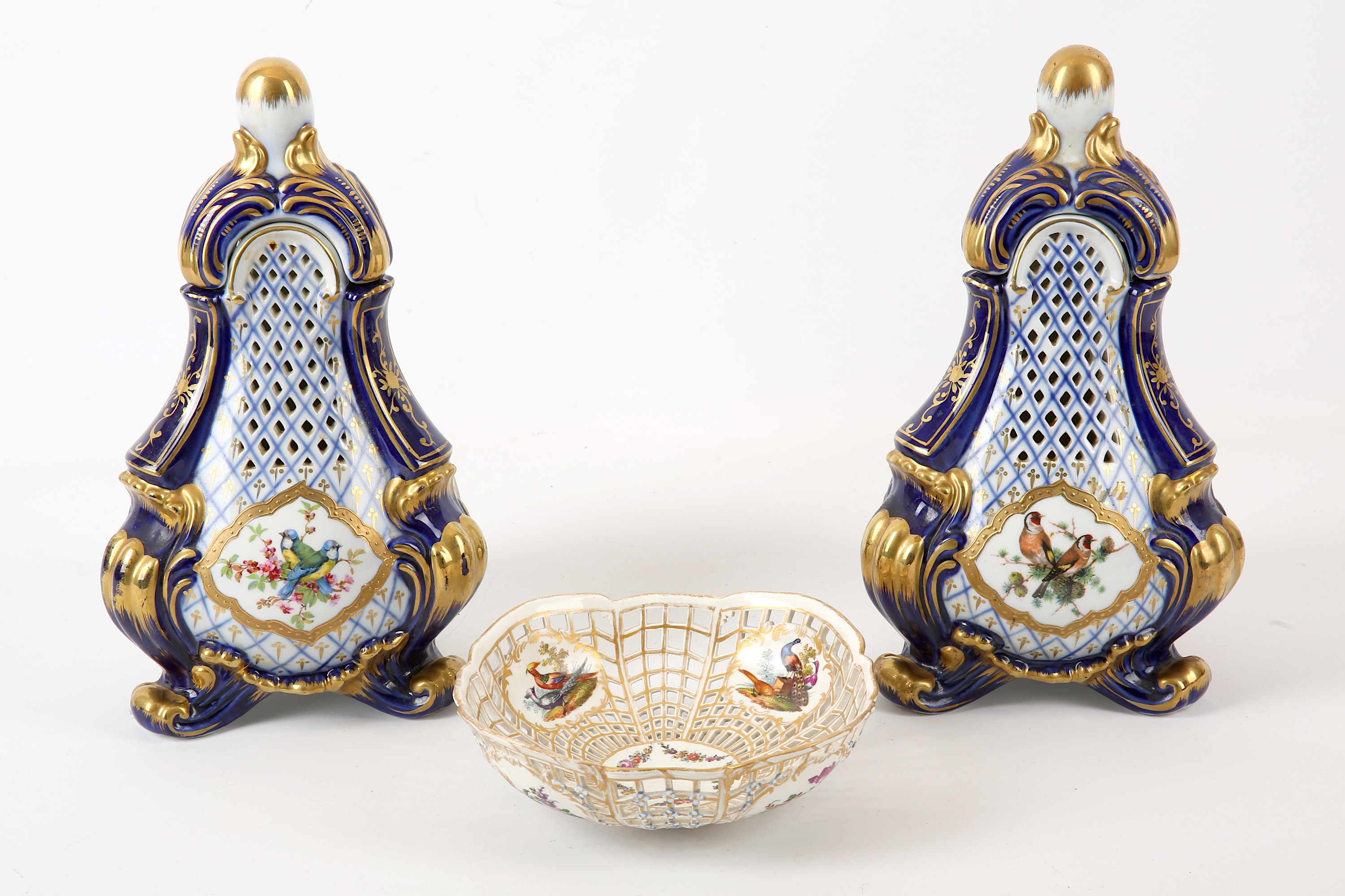 A pair of Continental porcelain reticulated vases and covers, both of three-sided tapered form,