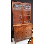 A George IV figured mahogany secretaire bookcase, with arched astragal glazed upper section over a