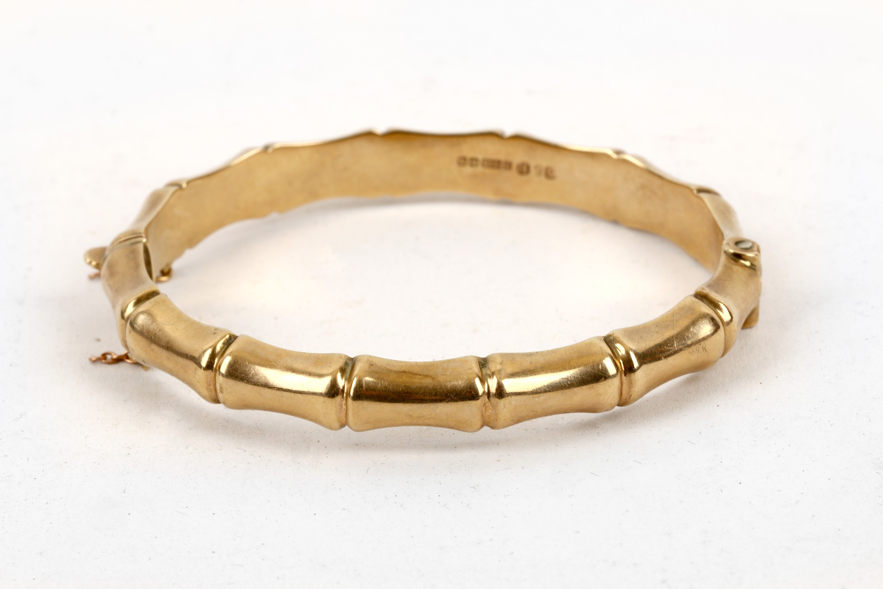 A gold bangle, of stylised bamboo design, mounted in 9 carat gold, UK hallmark, inner diameter 6.