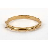 A gold bangle, of stylised bamboo design, mounted in 9 carat gold, UK hallmark, inner diameter 6.