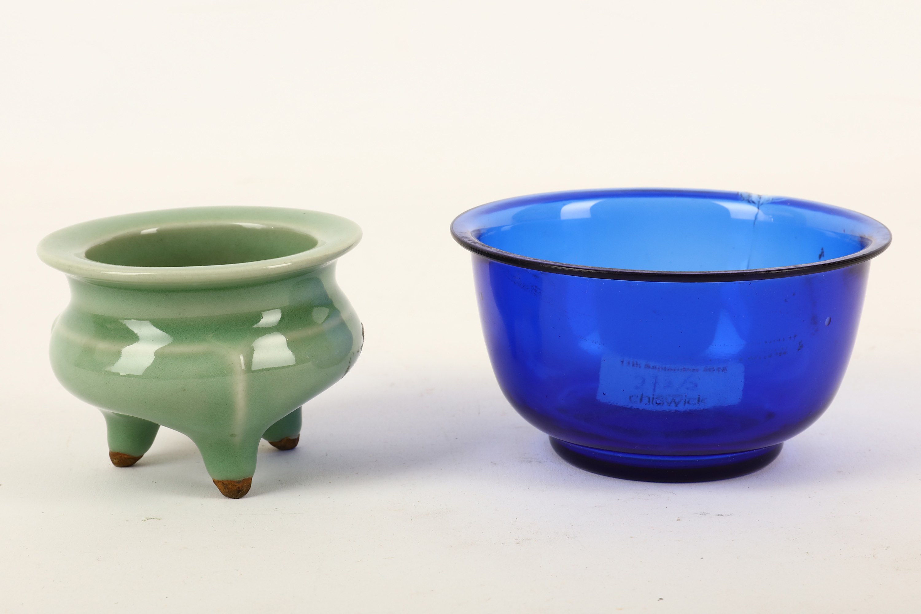 A Chinese celadon tripod censer and a blue Peking glass bowl, the body of the censer of compressed