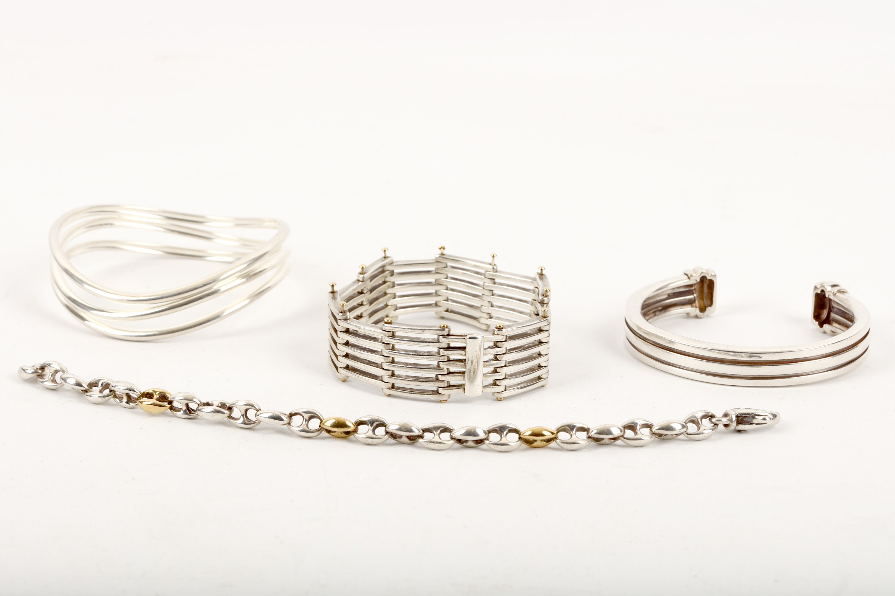 A small collection of bracelets, including a bi-coloured fancy-link bracelet by Tiffany & Co.,