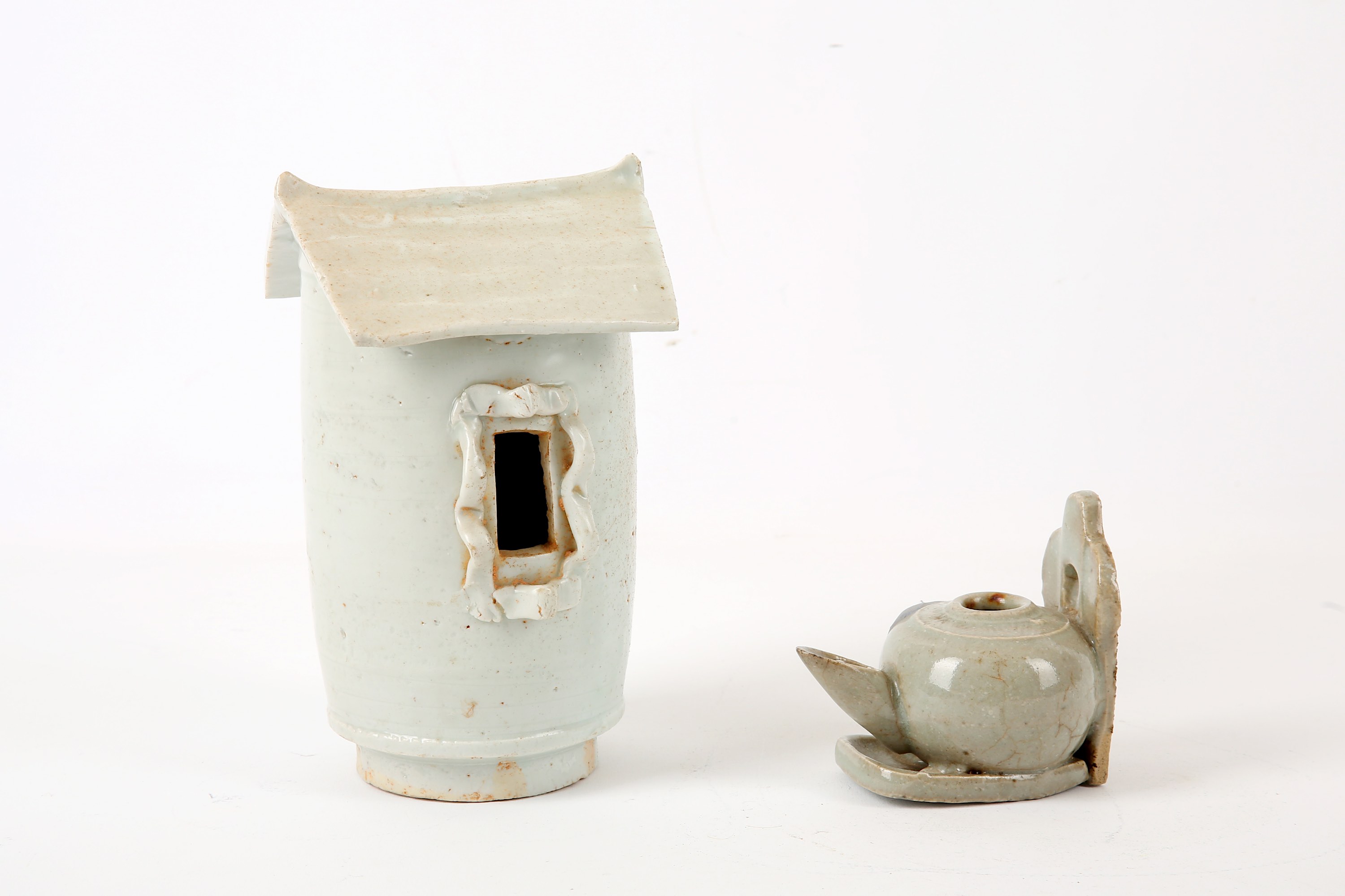 A Chinese glazed earthenware funerary model grain store, 20cm high; together with a celadon glazed