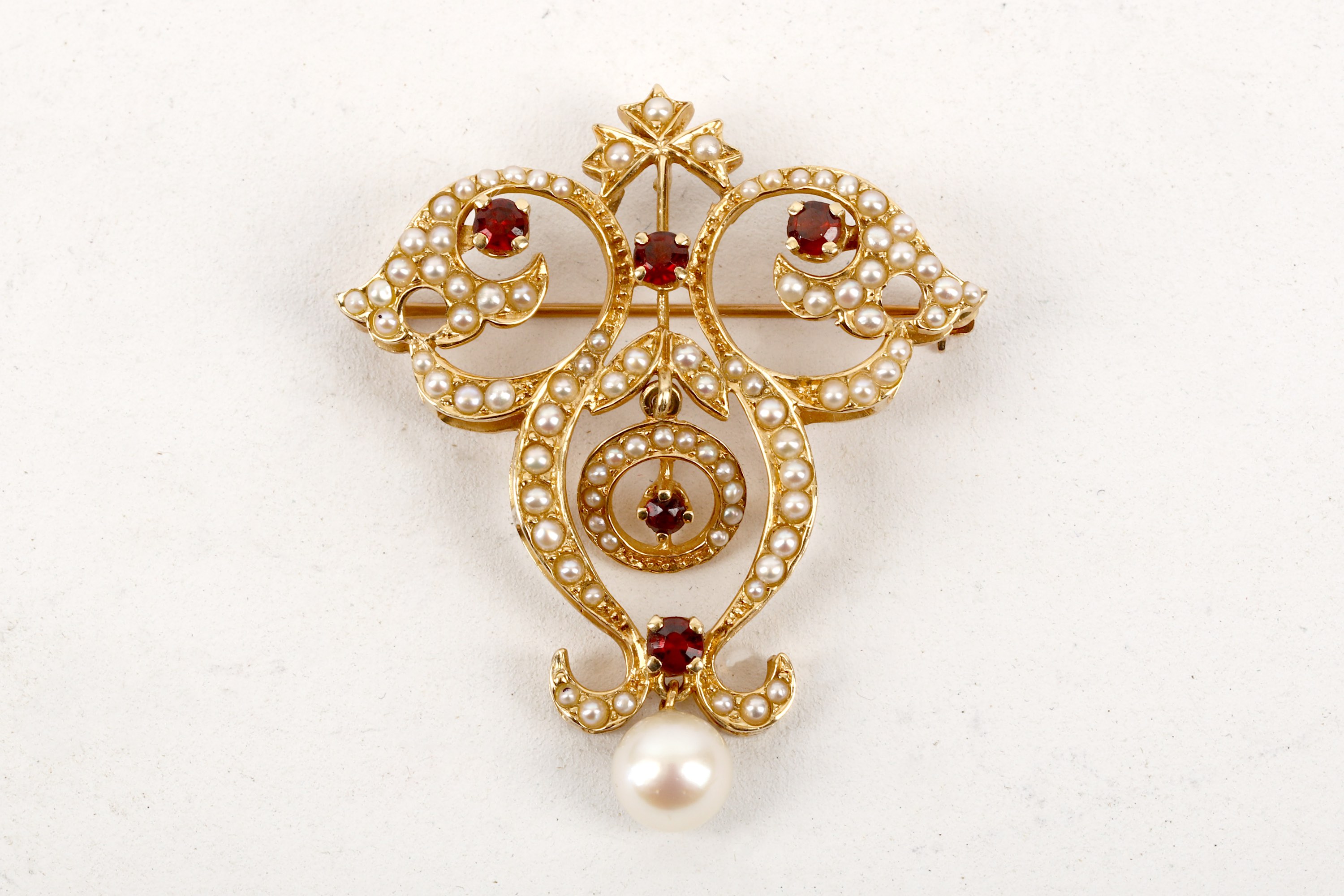 A garnet, pearl and gold pendant/ brooch, set in 14 carat gold with half seed pearls and garnets