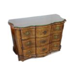 An 18th Century German Baroque commode, the shaped front fitted with three graduated drawers,