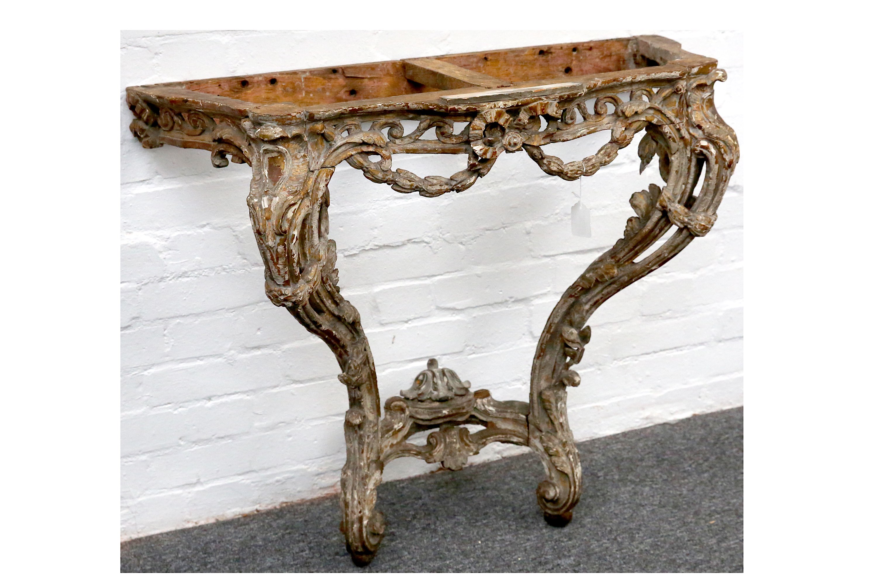 An 18th Century Italian carved wood serpentine console table, with traces of original plate, with