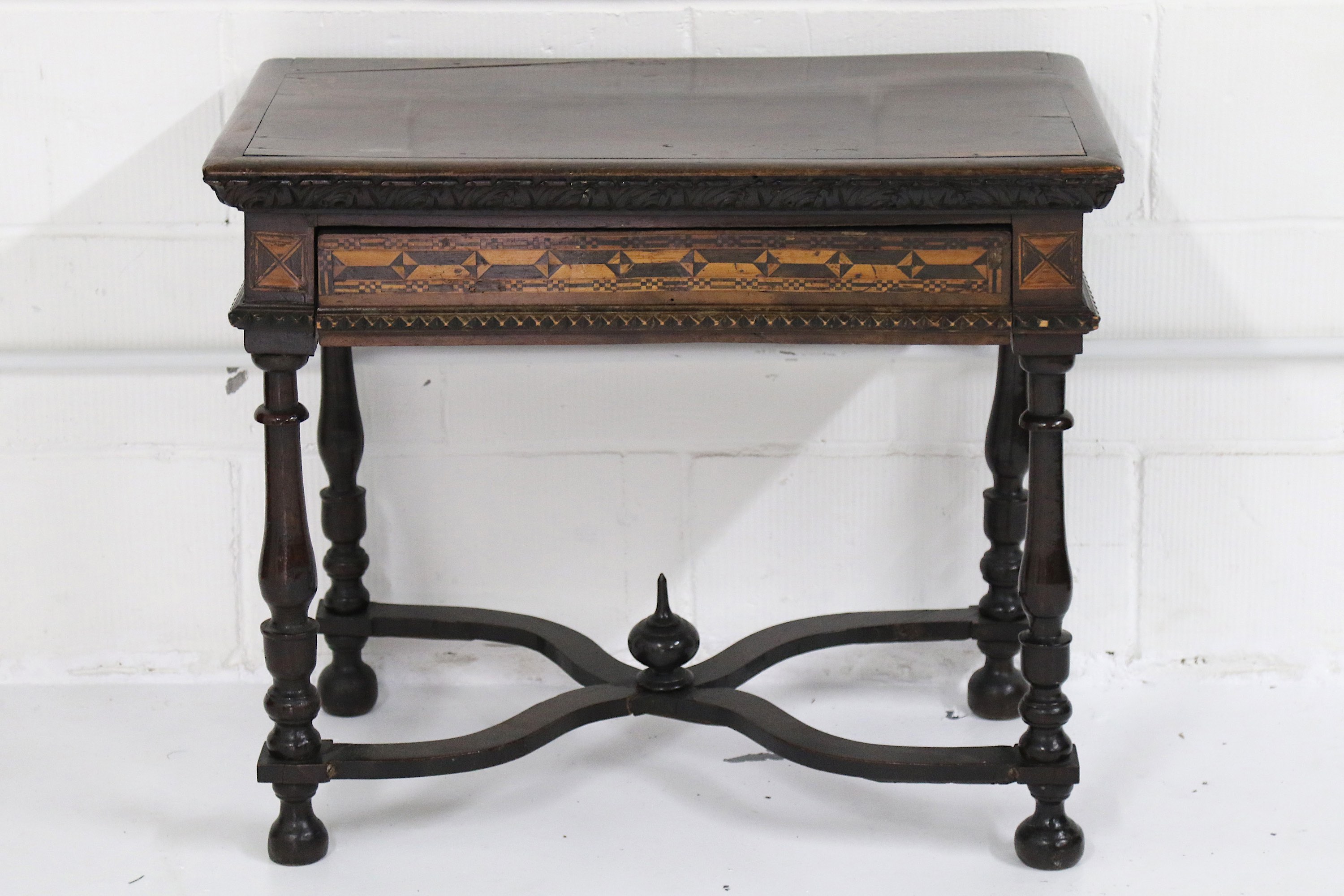 A 17th Century Italian walnut side table, the rectangular top with a carved leaf frieze, over a