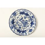 An 18th Century blue and white Bow porcelain plate, with scalloped rim and painted in dark blue with