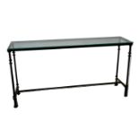 A modern design cast-iron console table, with a heavy cut glass top, raised on slim tapering legs,