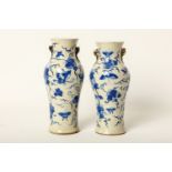 A near pair of Chinese blue and white pottery baluster vases, decorated with butterflies among