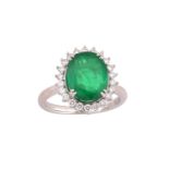 An emerald and diamond cluster ring