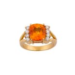 An orange sapphire and diamond ring