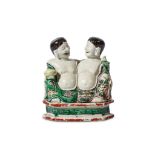 A CHINESE BISCUIT FIGURE OF THE TWINS ‘HEHE ERXIAN’. Kangxi. Well modelled, seated side by side,