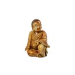 A CHINESE SOAPSTONE FIGURE OF A BOY. Kangxi. Seated in long flowing robes, the left hand holding a