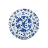 A CHINESE BLUE AND WHITE ‘PEONIES’ MOULDED DISH. Kangxi mark and of the period. Decorated with a