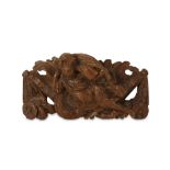 A 17TH CENTURY CARVED OAK RELIEF DEPICTING A PUTTO  the reclining putto riding on what appears to be