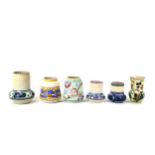 A collection of six Poole Pottery red bodied vases, decorated in traditional Art Deco style,