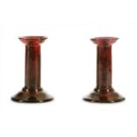 A pair of early 20th Century Royal Doulton candlesticks by Charles Noke and Harry Nicon,  each of