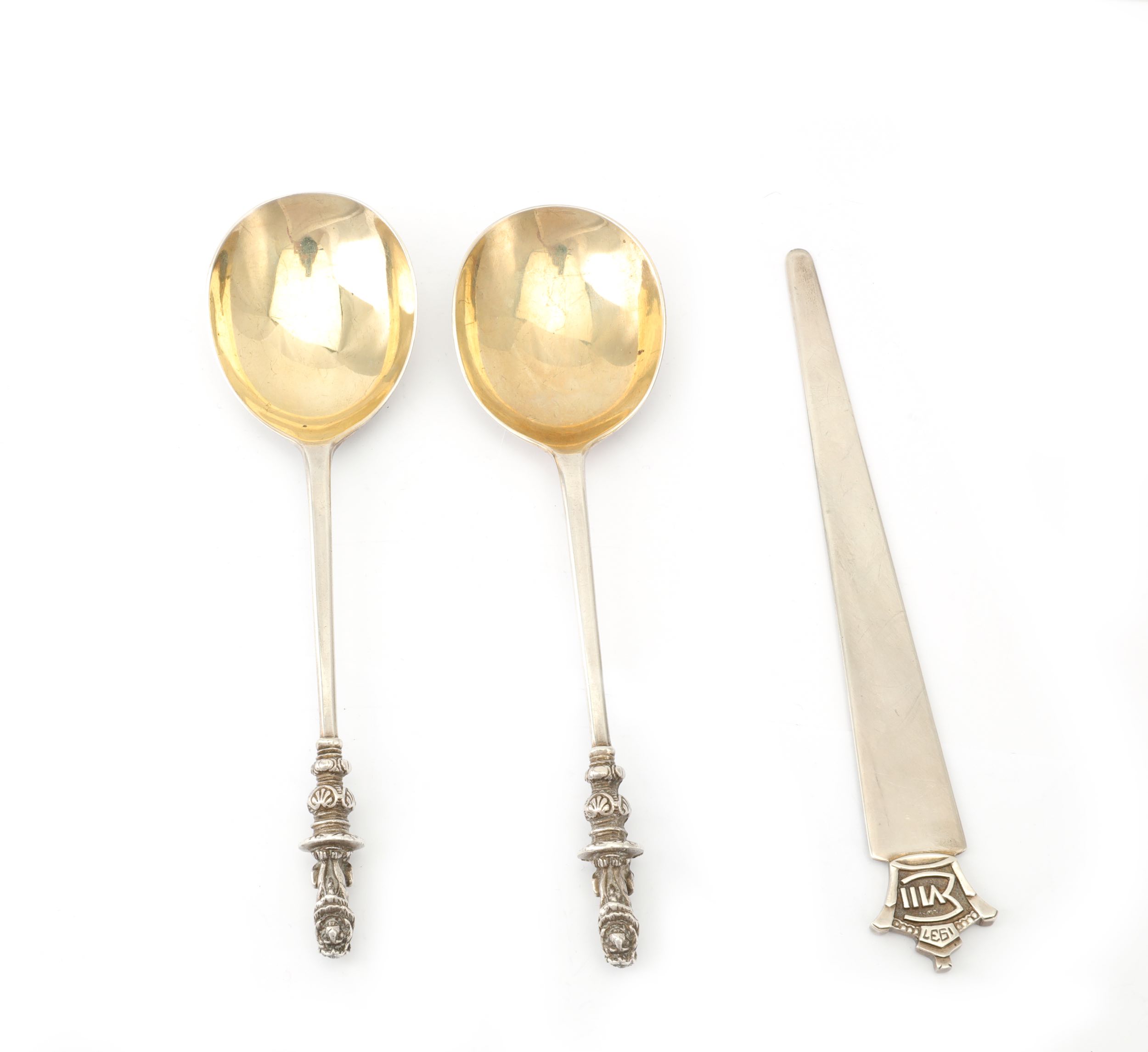 A mixed group of silver items to include a pair of George V lion sejant serving spoons with gilt bow