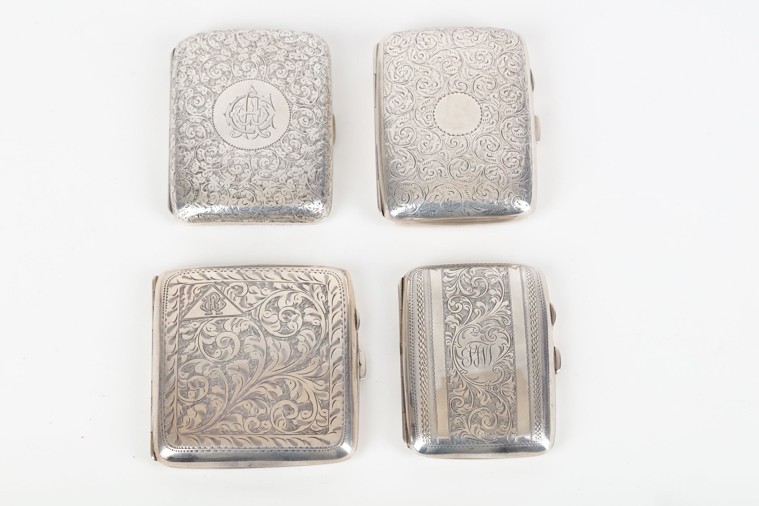 A mixed group of four engine-turned cigarette cases, Birmingham 1935, by Walker & Hall