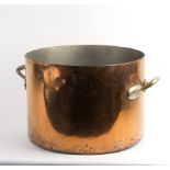 A large copper twin-handled cauldron with twin brass handles,