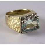 A diamond and blue topaz dress ring, the rectangular step cut topaz approximately 6mm wide,