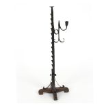 An iron floor standing adjustable rush light holder, on cruciform base,