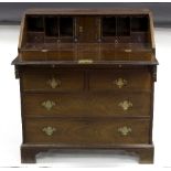 A George III mahogany bureau with fitted interior above an arrangement of two short and three long